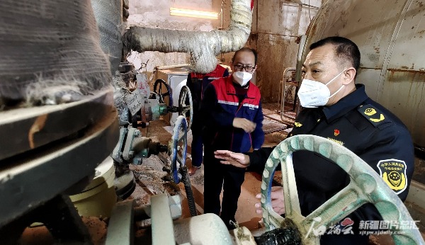12月26日，喀什地区市场监督管理局稽查支队队长高效东（右一）在南疆环球港国际酒店检查特种设备。石榴云/新疆日报记者 杨斌摄