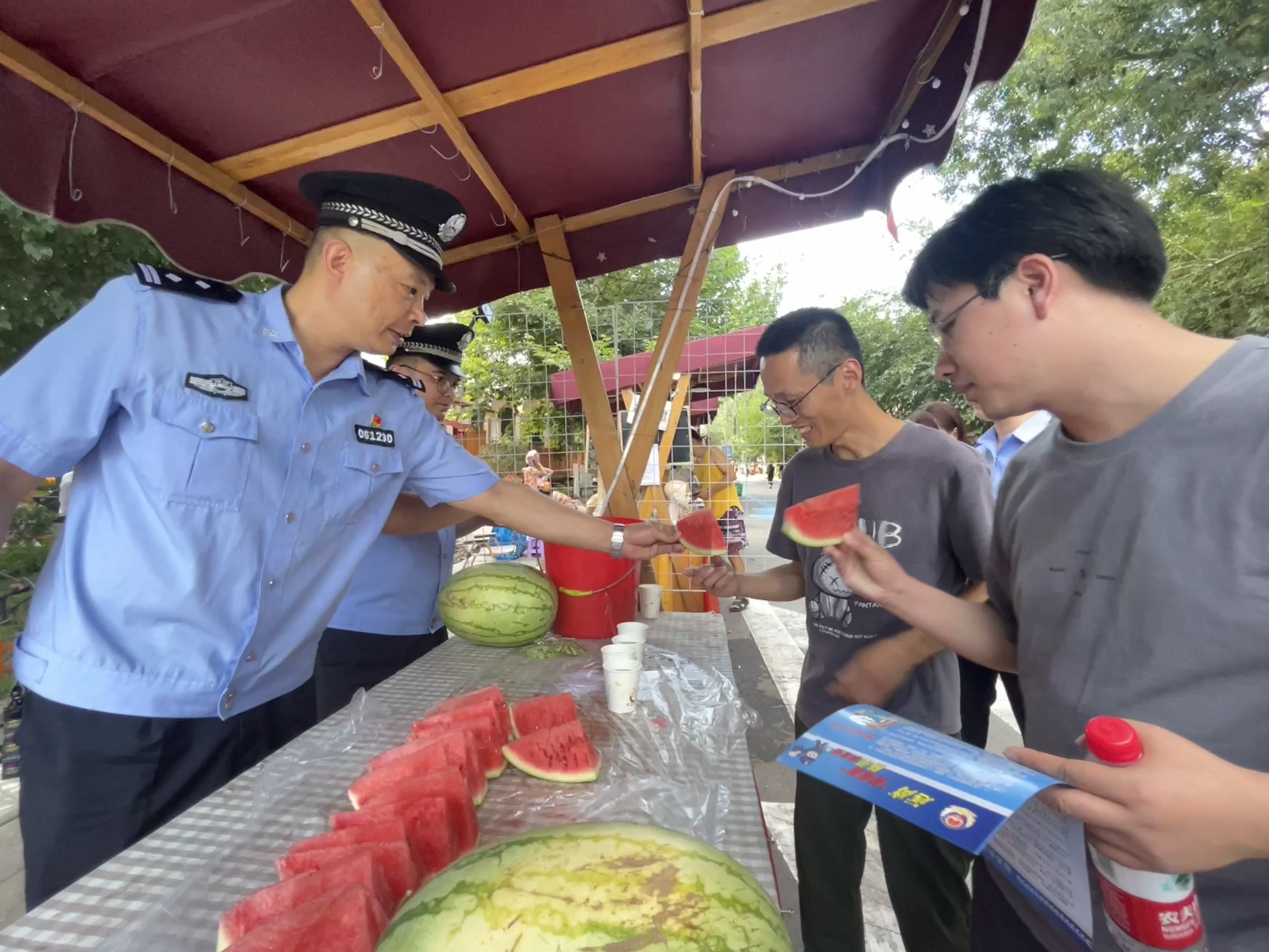 解放路派出所民警向六星街游客进行普法宣传工作并送去解暑的西瓜、绿豆汤。2.jpg