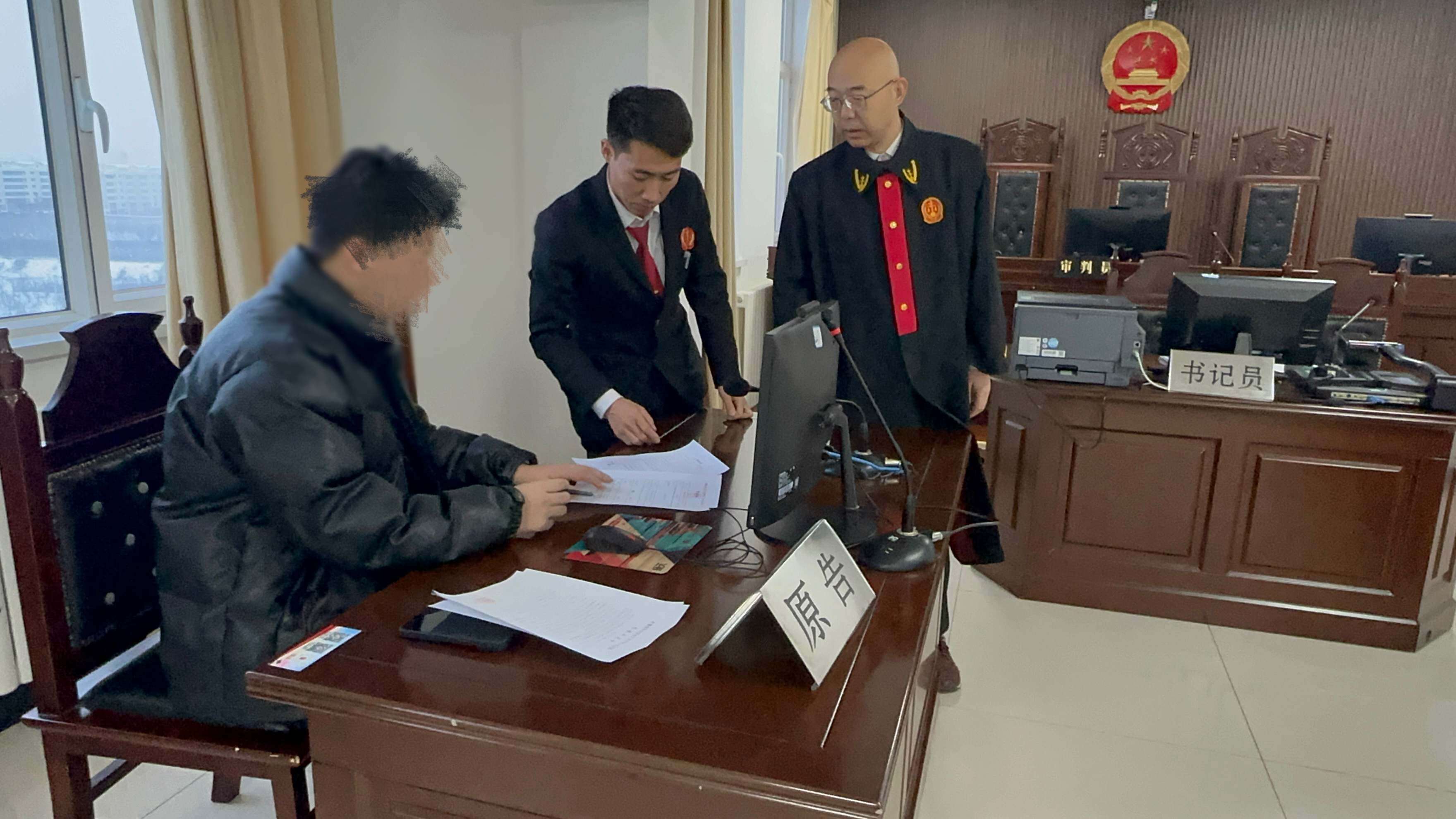 图为12月11日伊宁市人民法院行政（综合审判）庭副庭长马刚（右）向伊犁某建设工程有限公司开出罚款决定书.jpg