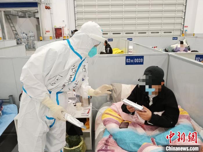 图为医护人员在方舱医院与患者沟通。　江苏省中医院供图