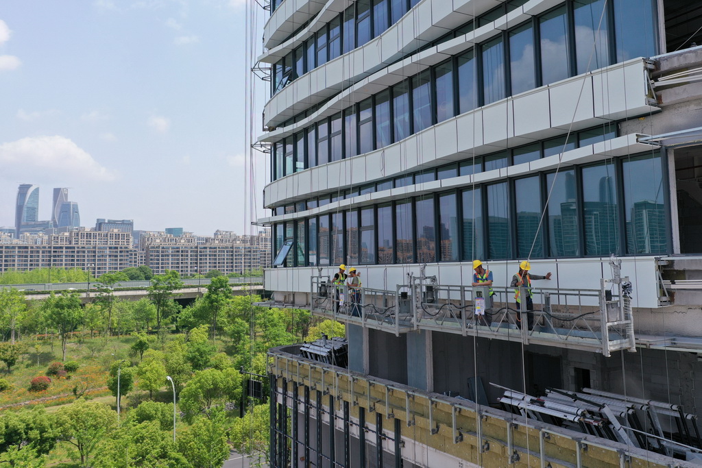 5月1日，中建四局建设者在浙江大学医学院附属妇产科医院钱江院区二期项目现场进行玻璃幕墙安装作业（无人机照片）。新华社记者 黄宗治 摄