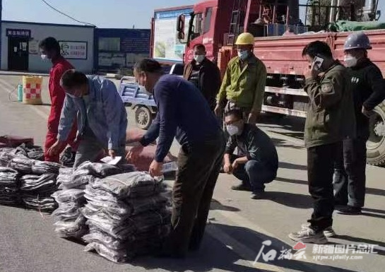 吐鲁番市高昌区一处建筑工地上正在给务工人员分发御寒衣物。吐鲁番市高昌区住房和城乡建设局供图