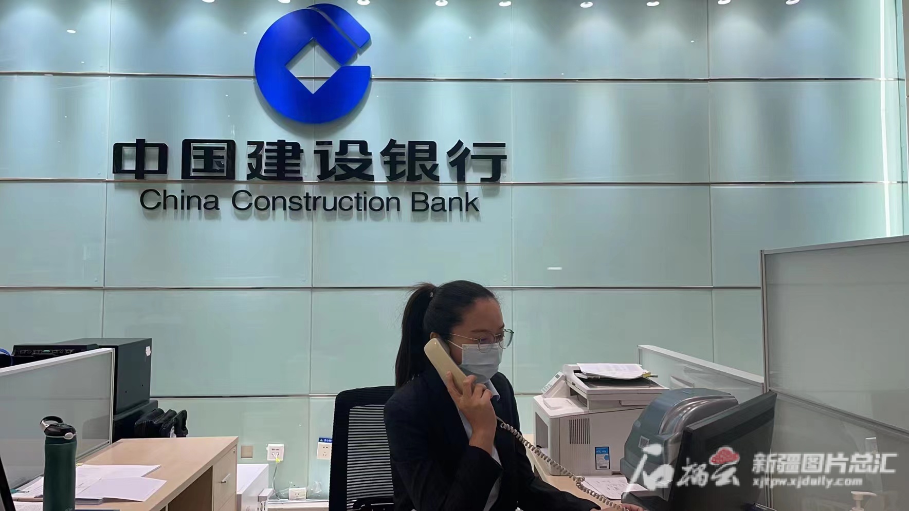 建设银行伊犁分行营业室工作人员在疫情期间电话受理相关金融业务咨询，为客户解决金融难题。通讯员李娟 摄