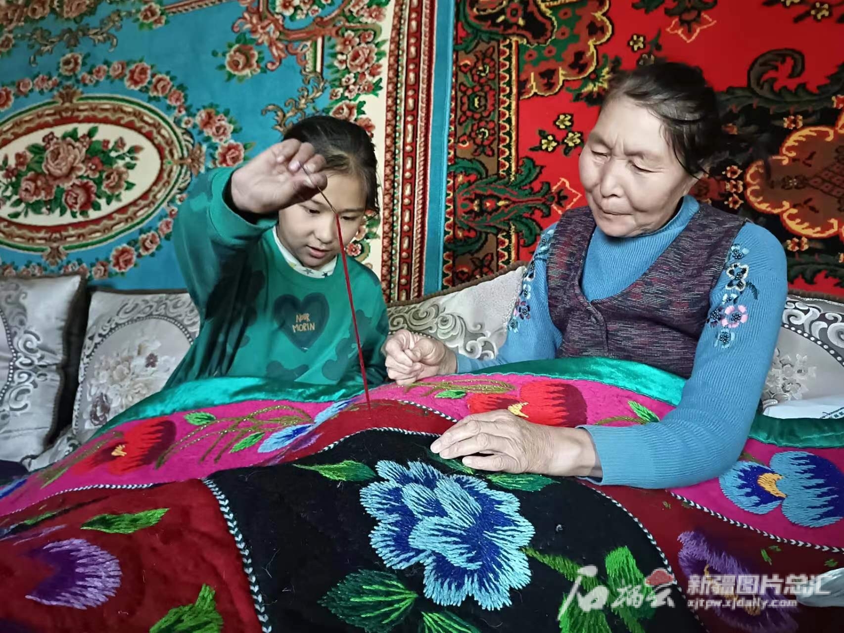 乌苏市白杨沟镇乌兰布拉克村村民奴尔古丽·吐尔斯别克正在给女儿教刺绣。金尕摄