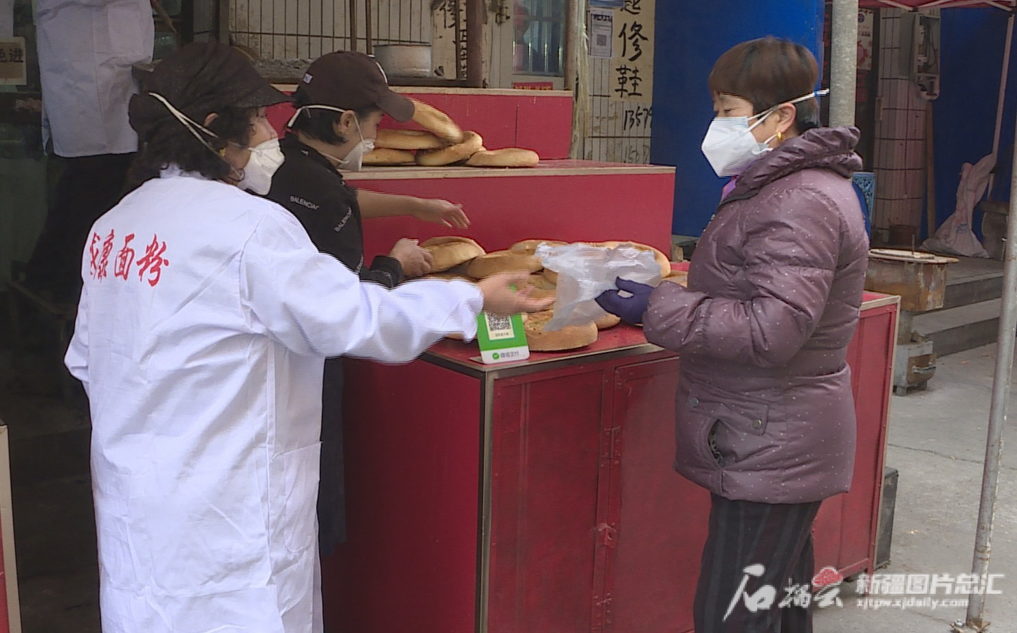 11月19日，在位于乌苏市老城区和谐巷的好巴郎馕店前市民正在购买馕。王兆云摄