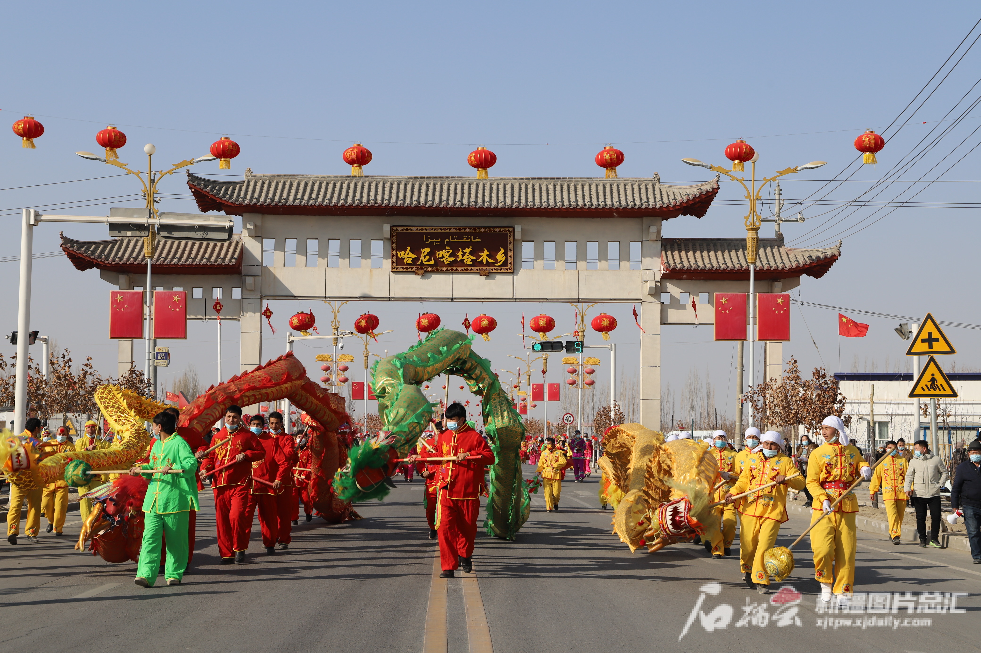 在库车市哈尼喀塔木乡主干道上，舞龙队正在表演舞龙。刘雪梅摄