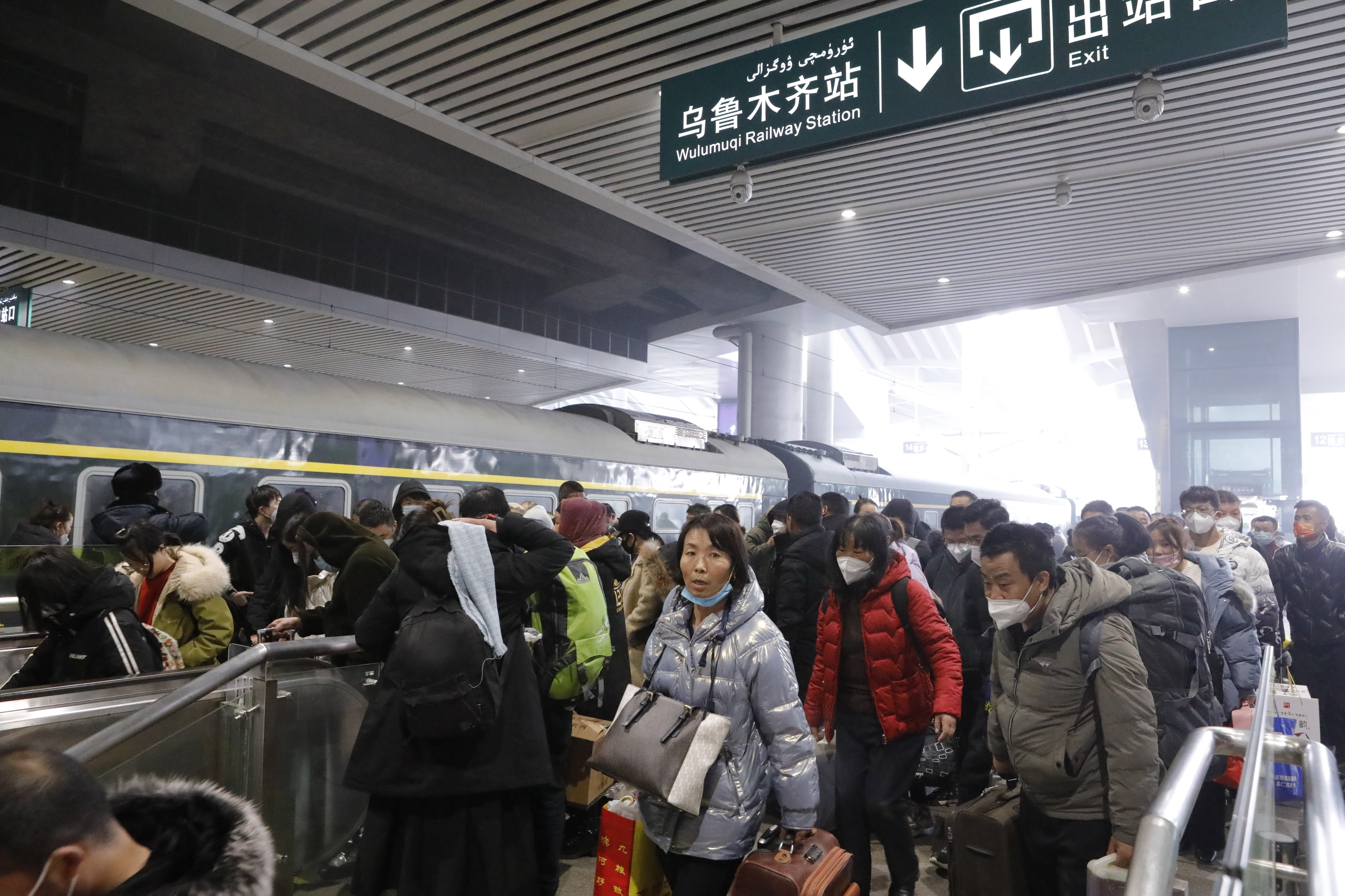 图说：2月1日12点14分，由兰州开来的节后首趟务工人员专列T3295次到达乌鲁木齐站，旅客正在有序出站。通讯员 徐涛 沈学武摄