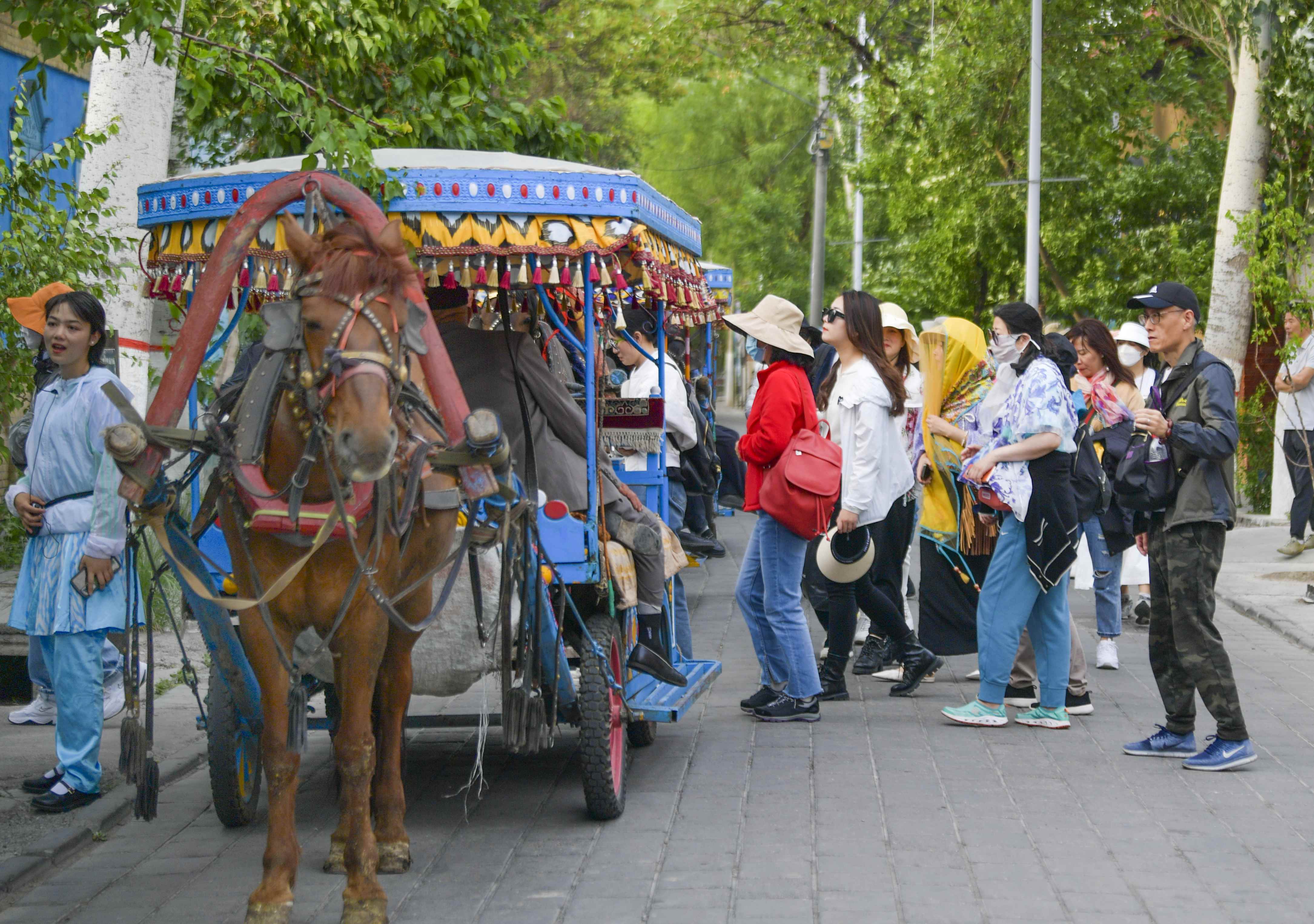 游客在伊犁哈萨克自治州伊宁市喀赞其民俗旅游区准备乘坐马车观光（5月18日摄）。（摄影：新华社记者王菲）