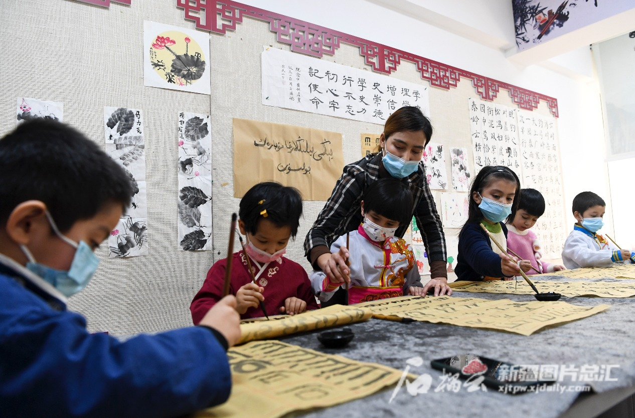 2022年1月14日，小朋友在乌鲁木齐市天山区二道桥街道固原巷社区开办的“六点半”课堂学习书法。  石榴云/新疆日报记者 汤永摄