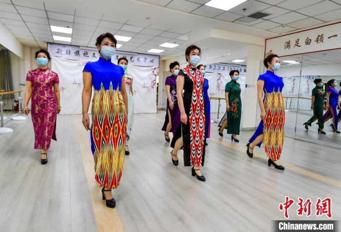 新疆旗袍文化馆模特队的队员身着融入艾德莱斯元素的旗袍训练走秀。　刘新 摄