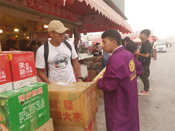 ▲交易中心的商户将打包好干果装箱称重。人民网记者陈新辉摄