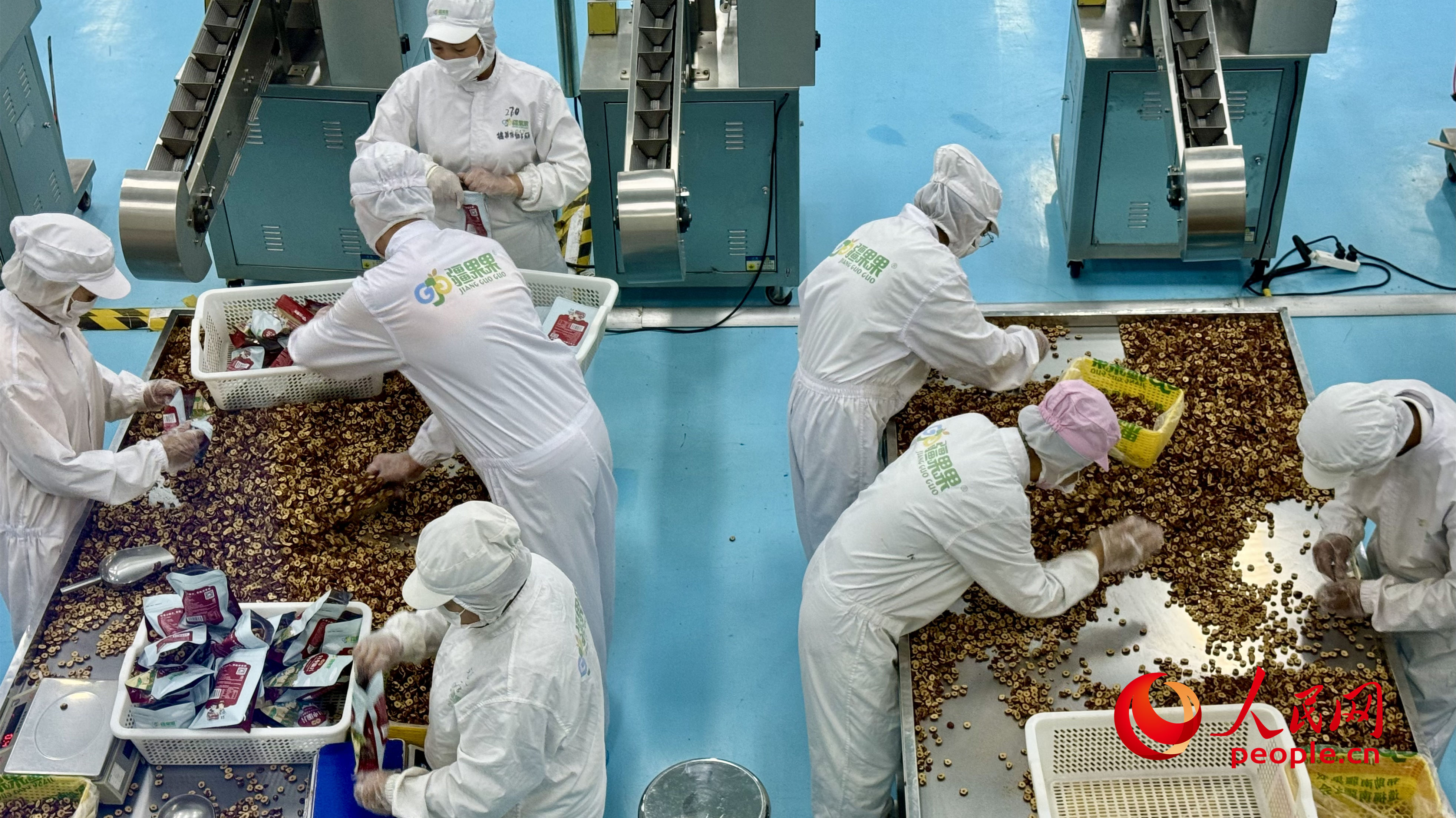 加工车间内，员工正在筛选干果。人民网 李龙摄