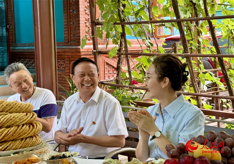 伊犁州政协委员、州工商联副主席华佳奎（中）参加“奶茶议事会”。人民网 李龙摄